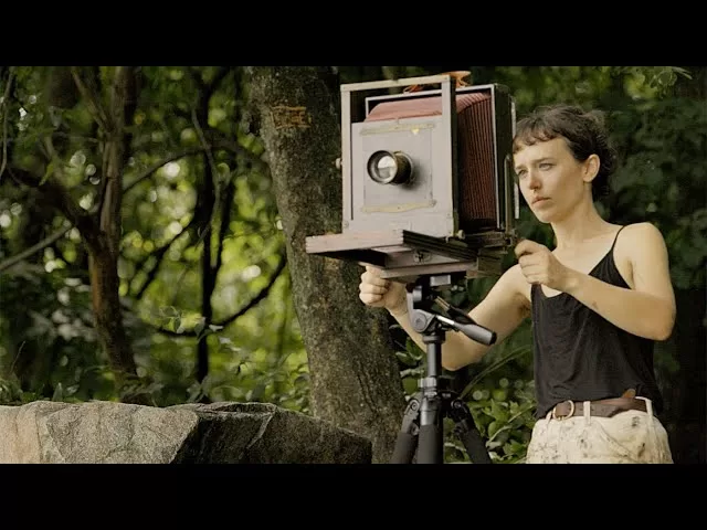 a photographer using a film camera in modern times